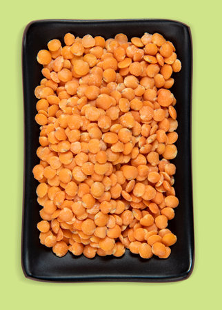 Red lentil in ceramic bowl isolated on pink background. Top view. Flat lay and clipping pathの写真素材