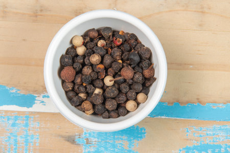 bowl with ground black pepper on blue rustic wooden table, top viewの写真素材