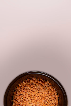 Red lentil in ceramic bowl isolated on pink background. top viewの写真素材