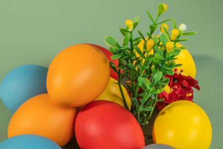 Colorful eggs symbolizing Easter on a colorful background and flowersの写真素材