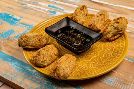 Fried codfish fritters in portions, with a bowl of olive oilの写真素材