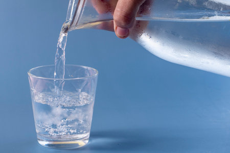 Unfilled glass of water on blue backgroundの写真素材