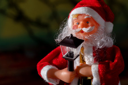 Santa claus doll with blurred christmas lights backgroundの写真素材