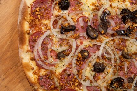 Brazilian pizza with pepperoni, cheese, onion and black olive , top viewの写真素材