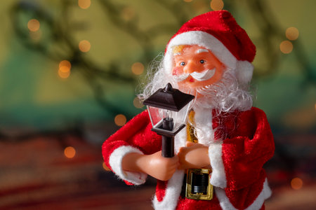 Santa claus doll with blurred christmas lights backgroundの写真素材
