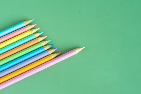 Pastel colored pencils, top view on green background, illustration concept, background and education and back to schoolの写真素材