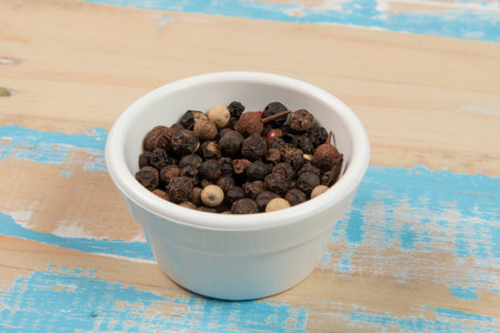 bowl with ground black pepper on blue rustic wooden table, up viewの写真素材