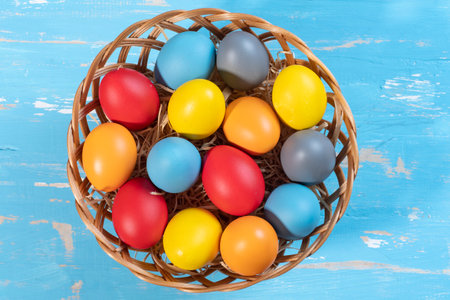easter basket with straw and colored eggs to symbolize a religious momentの写真素材