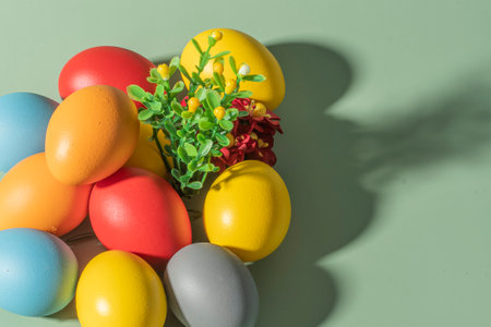 Colorful eggs symbolizing Easter on a colorful background and flowersの写真素材