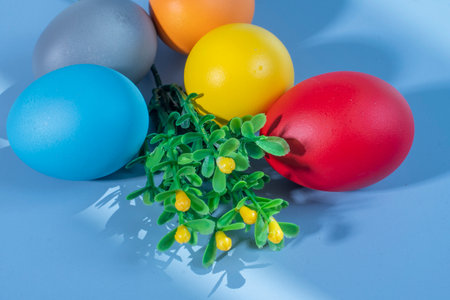 Colorful eggs symbolizing Easter on a colorful background and flowersの写真素材
