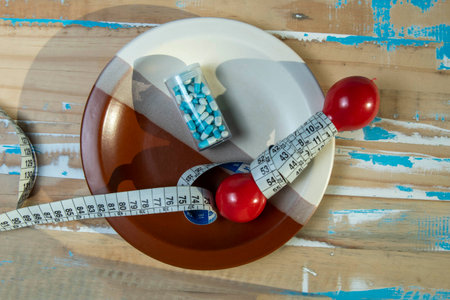 plate of food with an exercise weight inside symbolizing physical activity to lose weightの写真素材