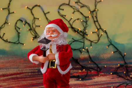Santa claus doll with blurred christmas lights backgroundの写真素材
