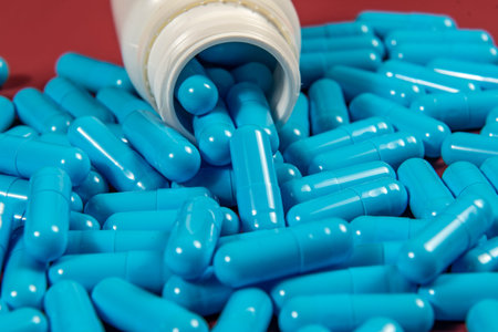 blue medicine capsules and white bottle symbolizing medicine