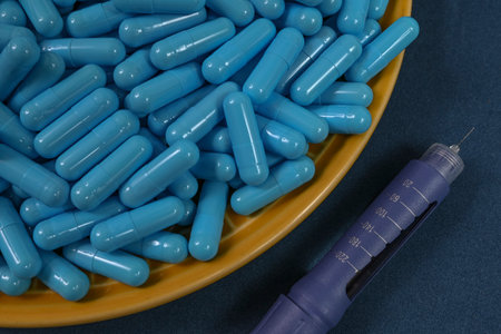 Yellow plate filled with blue medicine capsules representing drug overdose associated with diabetes and insulin. top viewの写真素材
