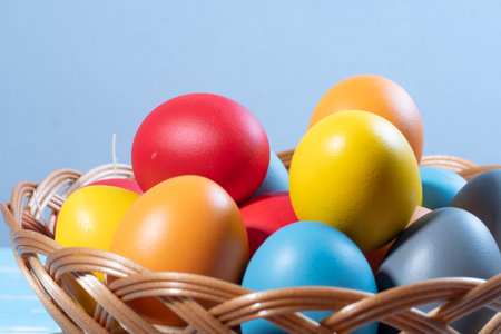 easter basket with straw and colored eggs to symbolize a religious momentの写真素材