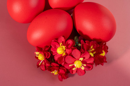 Colorful eggs symbolizing Easter on a colorful background and flowersの写真素材