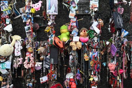 Santiago, Chile, October 22, 2023, objects of religious offerings hanging on the wall fulfilling...