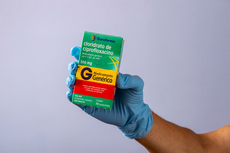 Rio, Brazil - January 27, 2023, hand with protective rubber glove holding medicine box, cipofloxacin hydrochlorideのeditorial素材