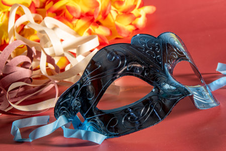 Venetian carnival mask with feathers and typical elements in the red backgroundの写真素材