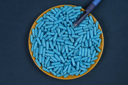 Yellow plate filled with blue medicine capsules representing drug overdose associated with diabetes...