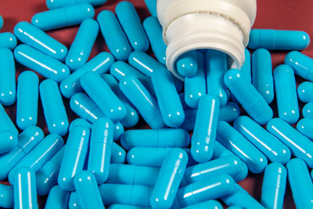 blue medicine capsules and white bottleの写真素材