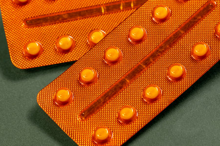 Vitamin D blister in original orange packaging on a green backgroundの写真素材