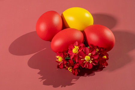 Colorful eggs symbolizing Easter on a colorful background and flowersの写真素材
