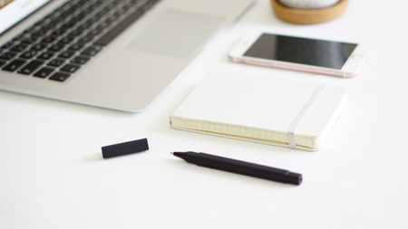 computer phone and notepad on the white background tableの写真素材