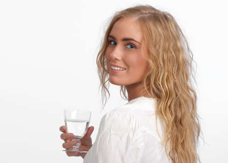Attractive, young, caucasian woman looking over her shoulder at camera, holding a glassの写真素材