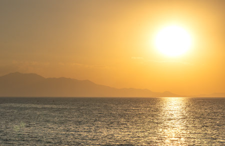Sunset over the sea with mountains in the background, Van. big looking sunの写真素材
