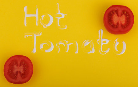 Tomatoes on a yellow background with the inscription hot food. The concept of healthy eating.の写真素材
