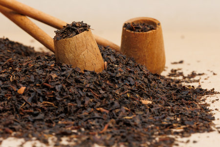 Dry black tea leaves in wooden spoons on wooden table.の写真素材