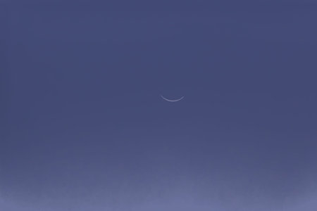 Crescent moon in the crystal clear blue sky, closeup of photo