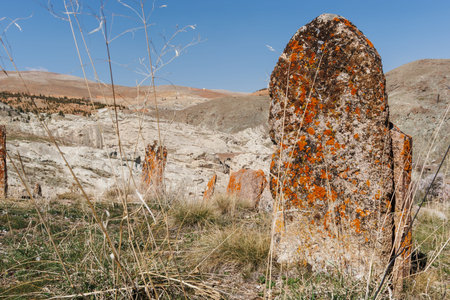 ancient stone grave stones in the cemetery under blue sky and mountain landscape in Konyaの写真素材