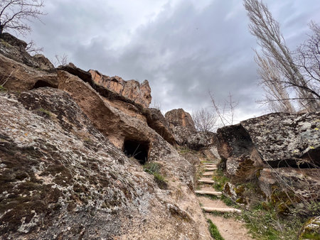 stone stairs among the rocky cliffs to the top of the mountain and cloudy skyの写真素材