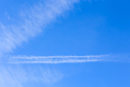 plane contrail and blue white clouds in the sky