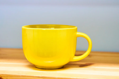 yellow cup on wooden shelf