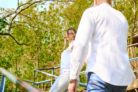 Young couple in love walking in the park holding hands looking in the sunny day