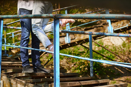 legs of young hugging couple on stairs in green park
