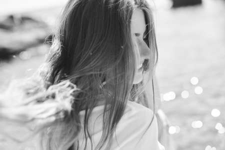 Summer lifestyle image of happy woman sitting on the cliff above the sea. Enjoying life and looking at the sea. Turquoise sea background.の写真素材