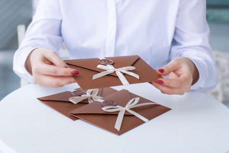 Gift Certificate, gift voucher or discount. close-up photo of bronze invitation envelope with a ribbon and wax seal, a gift certificate, a card, a wedding invitation cardの写真素材