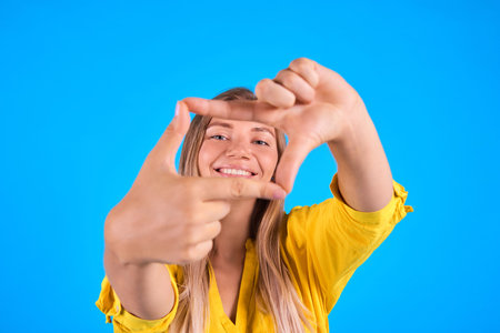 woman gesturing finger frame and smile. Focus on me concept