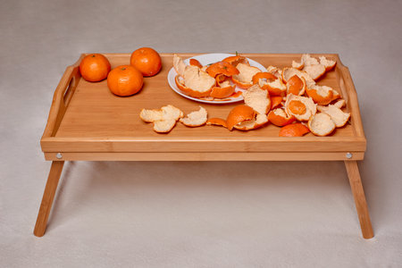 Mandarins on bed tray with legs. Concept of healthy food. Peel of tangerine and orangeの写真素材
