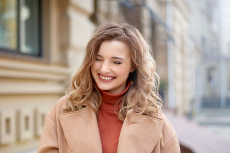 happy woman walk on street of town. Young stylish hipster girl wearing modern trench coat walking in urban city smiling happyの写真素材