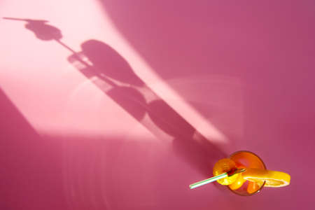 Refreshing juicy orange cocktail on bright pink background. Horizontal banner, poster with copy space. Summer cold drink with fruit in glass. Hard sunlight trend, long shadow, flat layの写真素材