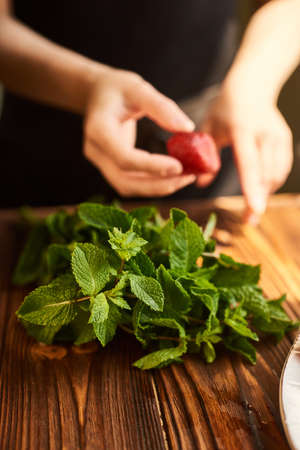 lime strawberry mint ingredients for making lemonade on white plate on wooden tableの写真素材