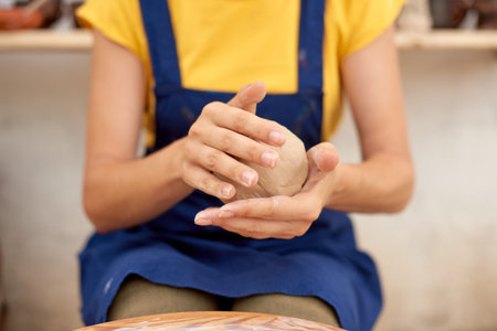 closeup of professional potter with wet clay pot in hands. pottery hobby woman hands sculpt in clay