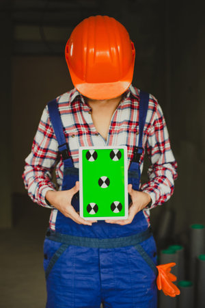 woman construction manager holding tablet device with green screen. architect or designer