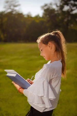child girl holding notebooks outdoor. Back to school conceptの写真素材