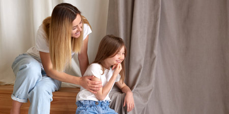 child girl smiling. mother talk to daughter. truce and love after a quarrel. happy and fun time to play together at homeの写真素材